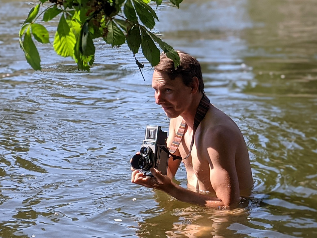 photographer shooting Flexaret while deep wading